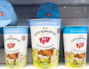 Doğal yoğurt kapları buzdolabında sergileniyor taze süt ürünleri sergileniyor, kaliteyi ve tadı vurgulanıyor, sağlıklı beslenme kavramı vurgulanıyor.