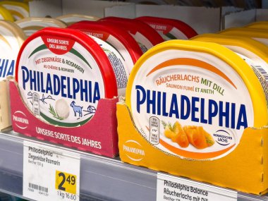 Kremalı Philadelphia peynir çeşitleri süpermarket raflarında sergileniyor, farklı tatlar ve ambalajlar sergileniyor, süt ürünleri seçimi, sağlıklı beslenme konsepti