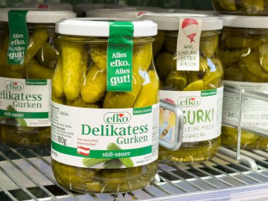 Rafta sergilenen cam kavanozlarda salatalık turşusu, canlı yeşil renkler ve çekici ambalajlar, yemek zevkleri ve sağlıklı beslenme konsepti için mükemmel.