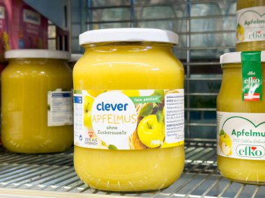 Süpermarketteki elma sosu kavanozunda parlak sarı renk ve marka etiketi sergileniyor. Sağlıklı yeme konsepti için mükemmel.