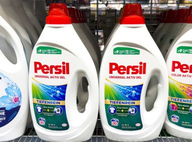 Persil çamaşır deterjanı şişeleri, etkili temizlik çözümleri ve çamaşır yıkama konsepti için çeşitli tipleri gösteren bir mağaza rafında sergileniyor.