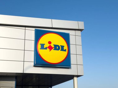 Perakende alışveriş deneyimi konseptini temsil eden parlak mavi gökyüzü logosu ve modern mimariye karşı Lidl süpermarket işareti