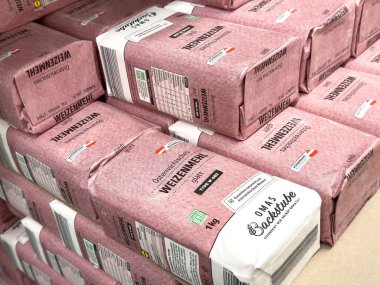 Hamur işi ve pişirme amaçları için çeşitli marka ve türlerde un içeren bir depoda istiflenmiş un torbaları, pişirme malzemeleri konseptinde kalite ve çeşitliliği vurguluyor