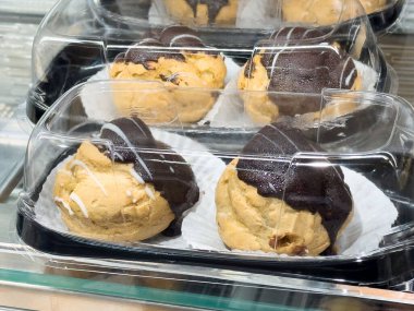 Bir pastane vitrininde sergilenen çikolata soslu kurabiye hamuru, zengin tatları ve çekici sunumları ile tatlı aşklarını cezbediyor, hoşgörülü tatlı konsepti