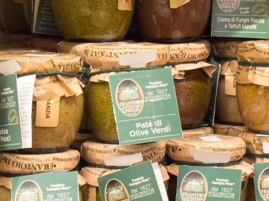 Market vitrinine istiflenmiş zeytin ezmesi kavanozları çeşitli aroma ve dokuları sergiliyor, sanatsal kaliteyi ve gurme gıda kavramını vurguluyor