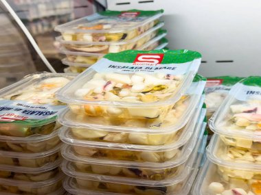 Temiz kaplarda taze paketlenmiş meyve salatası Sağlıklı Yeme Konsepti için bir marketin soğutulmuş bölümünde sergilenmektedir