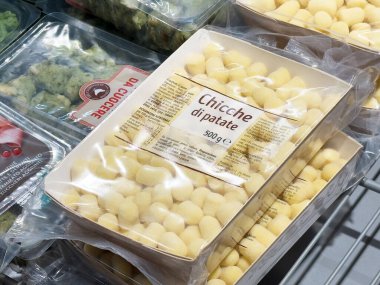 Gnocchi di patate paketleri bir market koridorunda sergilenen şeffaf plastik bir kapta İtalyan mutfağı ve makarna ürünleri sağlıklı beslenme konseptini sergiliyor.