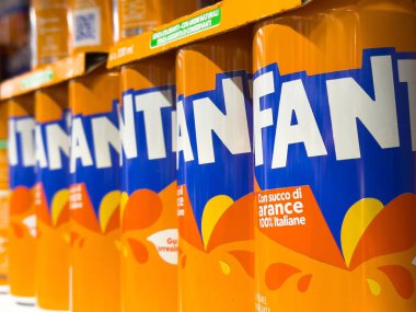 Fanta portakallı soda kutuları bir süpermarketin rafına dizilmiş canlı renkler ve markalaşma, tüketiciler için ferahlatıcı içecek seçimi, içecek pazarlama kavramı sergiliyorlar.