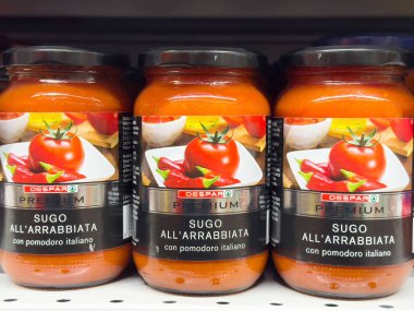 Sugo 'Arrabbiata kavanozları mağazanın rafında canlı domates sosu sergileniyor, makarna yemekleri ve mutfak icatları için mükemmel, İtalyan mutfağı konsepti