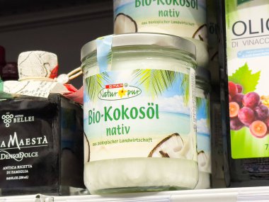 Süpermarkette sergilenen organik hindistan cevizi yağı kavanozunda doğal malzemeler ve yemek pişirme ve cilt bakımı için sağlıklı yaşam biçimi seçenekleri sergileniyor.