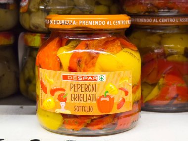 Markette canlı sarı ve kırmızı sebzelerin sergilendiği renkli biber kavanozu lezzetli ve keskin bir lezzet konseptini sergiliyor.