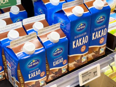 Çikolatalı süt kutuları, enfes bir içecek konsepti için bir süpermarket rafına yerleştirilmiş markalaşma ve paketleme tasarımı.