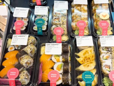 Renkli suşi tabakları çeşitli dürümler, sashimi ve süslemeler sergiliyor. Lezzetli bir yemek için mükemmel, suşi kavramı.