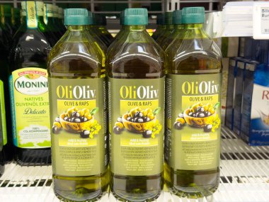 Bir süpermarketin rafında sergilenen zeytinyağı şişeleri kaliteli, zengin lezzet ve yemek pişirme ve giyinme için sağlık sigortası, sağlıklı beslenme konsepti sunar.