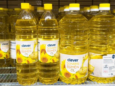 Süpermarket raflarında sergilenen ayçiçeği yağı şişeleri canlı ambalajlar ve markalaşma ve aşçılık kullanımları için markalaşma, sağlıklı aşçılık kavramları sunuyor.