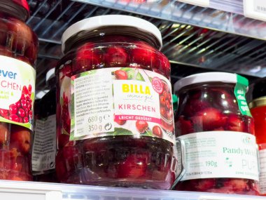 Freshly preserved cherries in jars displayed on a supermarket shelf showcasing vibrant colors and appealing packaging, perfect for culinary delights and healthy eating concept clipart