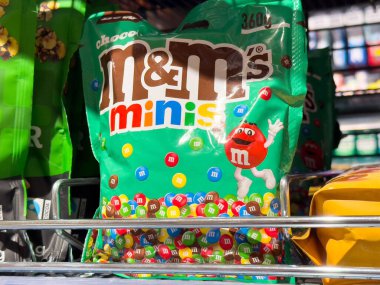 Colorful M&M's Minis Candy Pack Displayed on Store Shelf, Tempting Treat for Sweet Lovers, Perfect for Sharing and Enjoying, Candy Lovers Delight, Sweet Snack Concept clipart