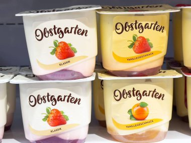 Rafta sunulan lezzetli meyveli yoğurt fincanları canlı tatlar ve çekici ambalajlar sağlıklı atıştırma ve tatlı seçenekleri için mükemmel, yoğurt konsepti.