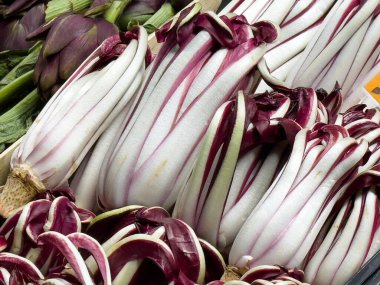 Fresh radicchio and artichoke display at a farmer's market. clipart