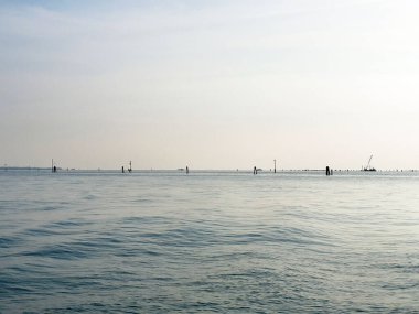Sakin okyanus ufku, berrak gökyüzünün altındaki uzak yapılar..