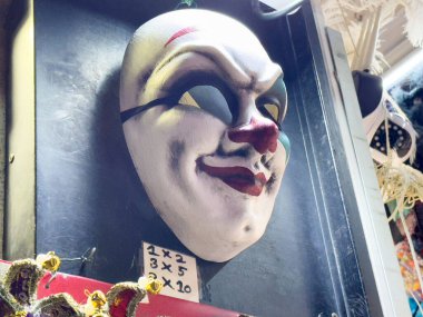 Sokak pazarında duvarda joker tasarımı gösteren maske.