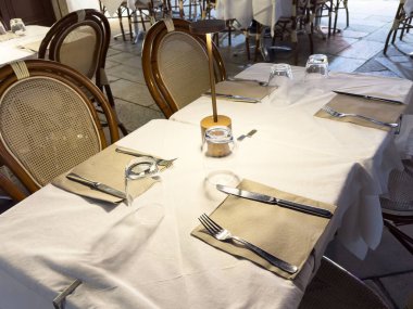 Sofra kurulumu ve ahşap sandalyeli şık bir açık hava yemek düzeni..