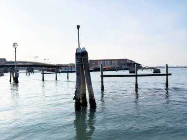 Berrak gökyüzü altında sakin ve sakin bir rıhtım manzarası..