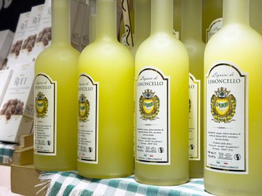 Damalı kumaş üzerinde sergilenen İtalyan limoncello likörü şişeleri.