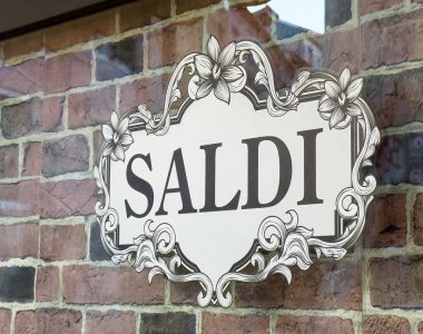 Tuğla duvarda satışı gösteren zarif çiçek tabelası..