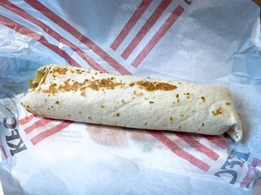 Kırmızı çizgili markalı kağıda KFC tavuk dürümü.