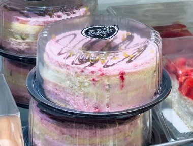 Vitrindeki plastik kutuda nefis pembe katmanlı kek..