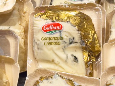 Tahta tepsi ambalajında altın ambalajlı kremalı gorgonzola peyniri.