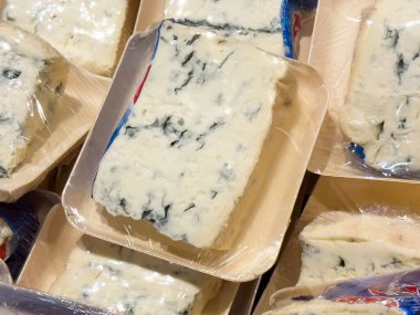 Ahşap tepsilerde paketlenmiş mavi peynir dilimlerinin yakın çekimi.