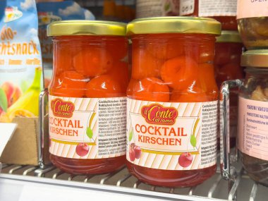 Süpermarket raflarında cam kavanozlarda kokteyl vişneleri.