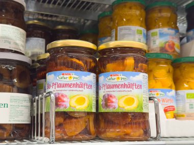 Rafta organik erik parçaları ve kavanozlarda saklanmış diğer meyveler var..