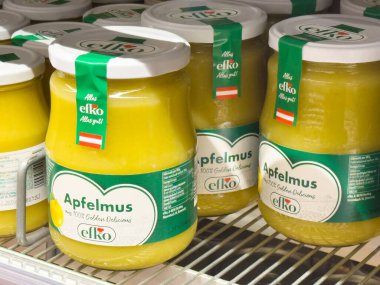 Rafta yeşil ve beyaz etiketli sarı apfelmus kavanozları.