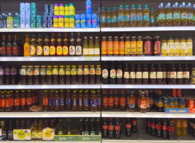 Markette çay, soda ve meyve suyu şişeleriyle dolu renkli içecek koridoru..