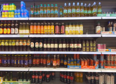 Süpermarket koridorundaki çeşitli içecek rafları geniş bir içecek yelpazesini gösteriyor.