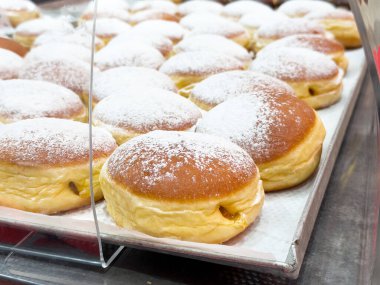 Pastane tepsisinde sergilenen lezzetli pudra şekerli çörekler..