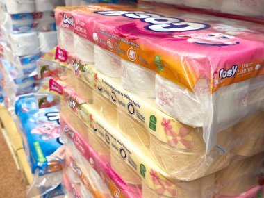 Mağaza raflarında renkli tuvalet kağıdı ruloları.