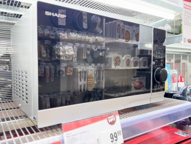 Elektronik mağazasındaki raflarda keskin mikrodalga fırın.