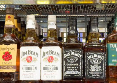 İçki dükkanının rafında viski ve tennessee viski şişesi seçimi.