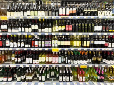 Süpermarket rafında geniş bir şarap şişesi seçimi..