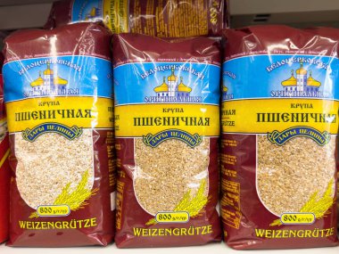 Ambalajlı buğday, mağaza rafında kırmızı ve mavi torbalarda inliyor..