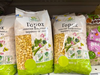 Erzak rafında yeşil bezelye ve beslenme etiketleriyle paketlenmiş sarı bezelye..