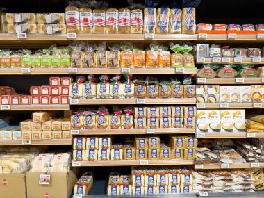 Market raflarındaki paketlenmiş ekmek ve fırın ürünlerinin çeşitliliği.