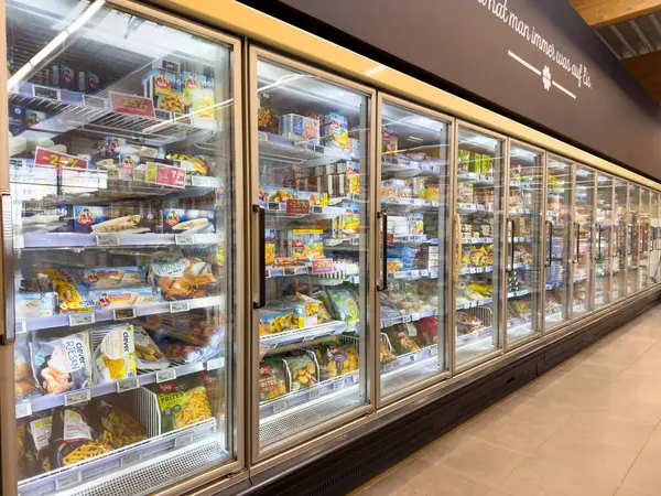 Süpermarkette dondurulmuş gıda reyonu. Cam kapılı dondurucuda çeşitli ürünler var..