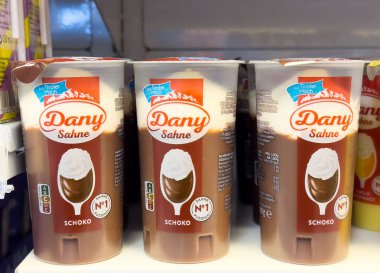 Çikolatalı tatlı bardakları gıda etiketleriyle dolu raflarda..