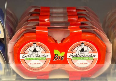 Mağazada kırmızı ambalajlı organik Alman peyniri paketleri.