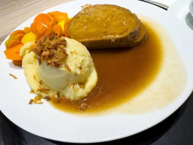 Patates püresi ve bol kahverengi soslu havuçlu tuzlu köfte..